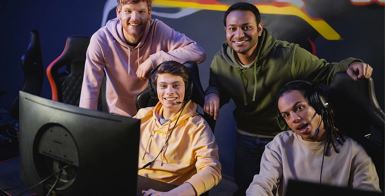 Giocatori esports di diverse origini sorridono insieme in un'arena di gioco prima dell'inizio di una partita.