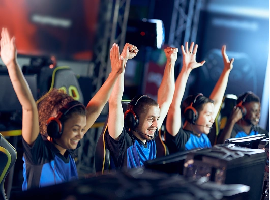 I membri del team alzano le mani in segno di vittoria dopo aver vinto una competizione esports.